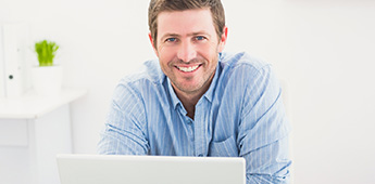 Smiling man using a laptop computer